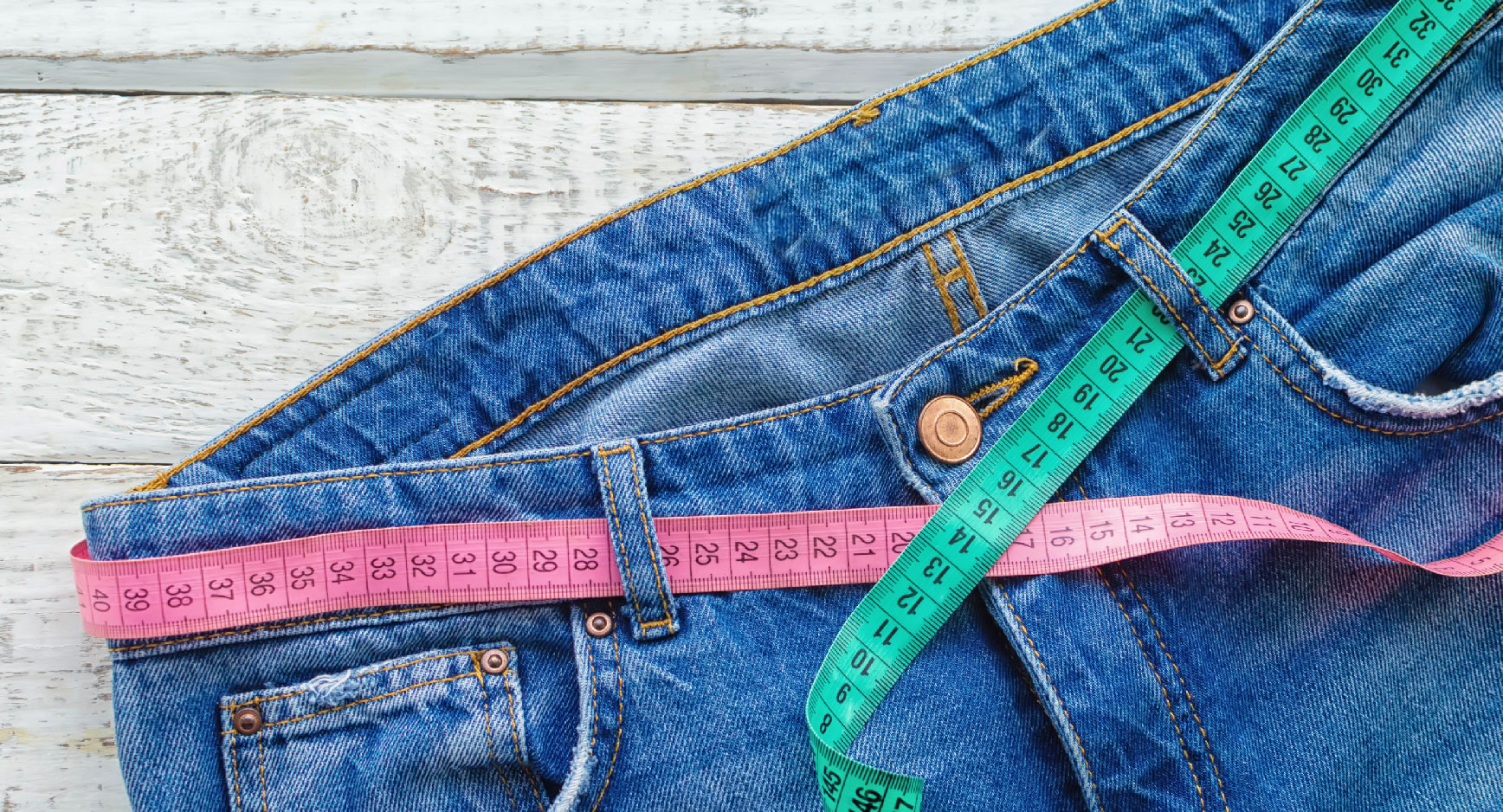 Jeans mit zwei Maßbändern um den Bund